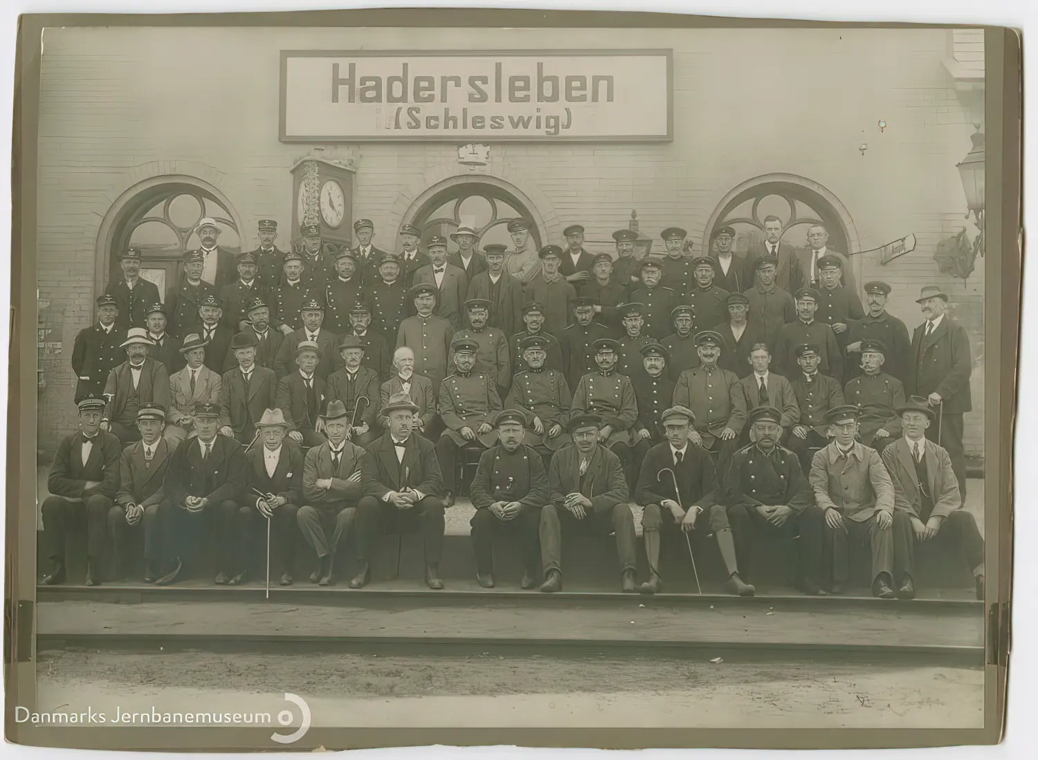 Billede af det tyske og det danske jernbanepersonale opstillet til fælles gruppefotografering forud for den danske overtagelse af Haderslev Vestbanegård natten mellem den 16. og 17. jun. 1920. Billede af det tyske og det danske jernbanepersonale opstillet til fælles gruppefotografering forud for den danske overtagelse af Haderslev Vestbanegård natten mellem den 16. og 17. jun. 1920.