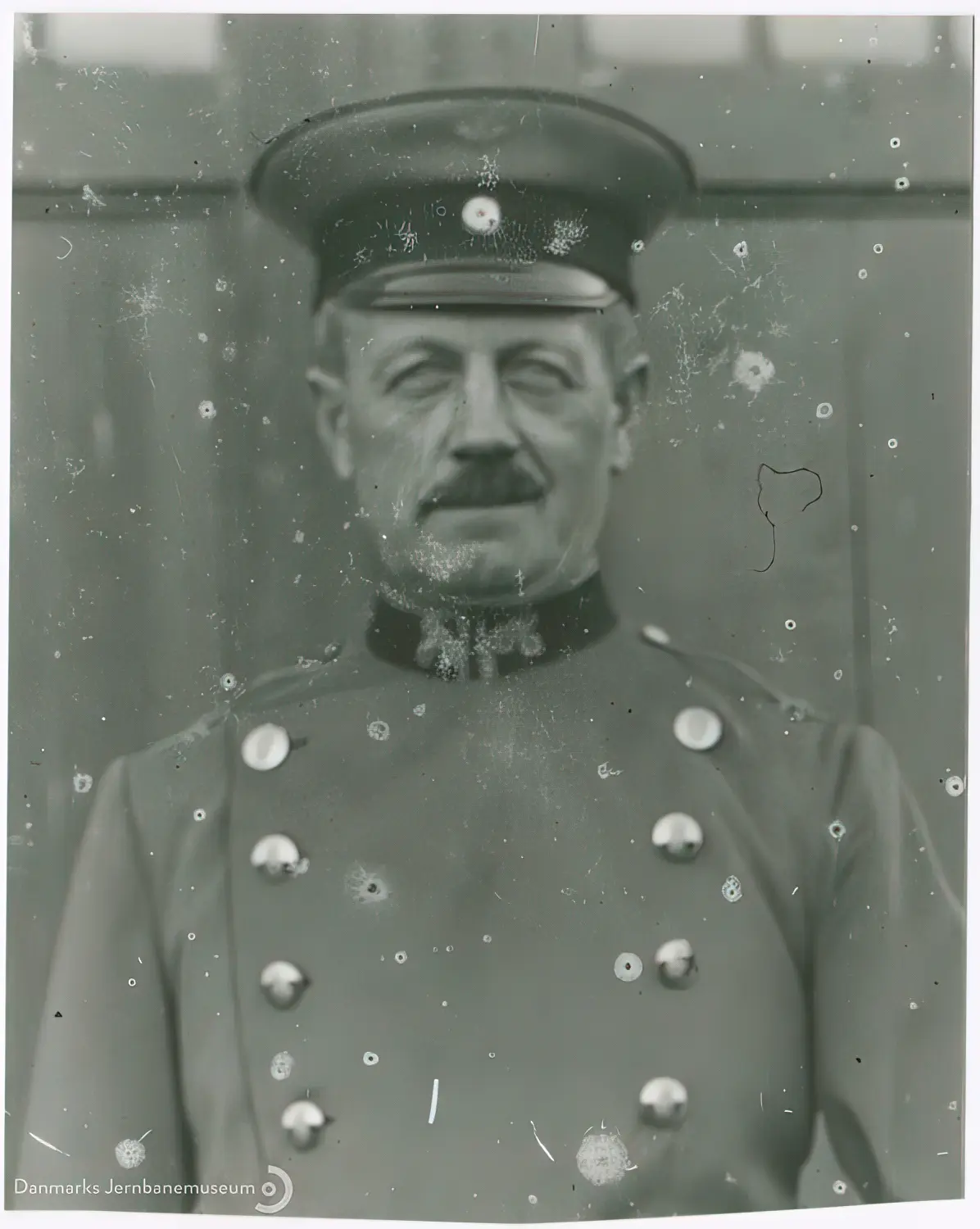 Billede af den tyske stationsforstander (navn uidentificeret) umiddelbart før uniformsskiftet ved overgangen til dansk tjeneste efter Genforeningen på Dynt Station.