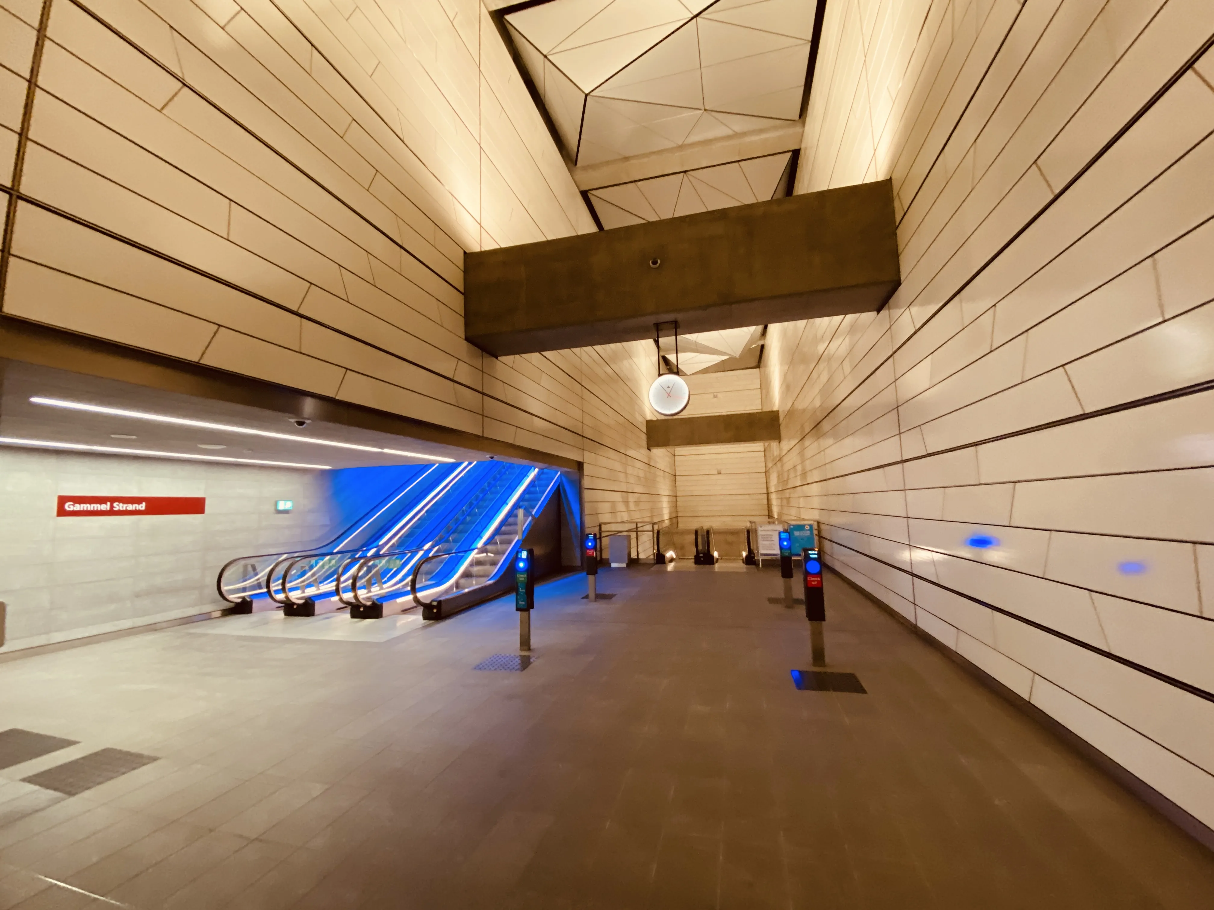 Billede af Gammel Strand Metrostation med et blåt lysspil, som er en hilsen til sollyset i vandoverfladen i Gammel Strands kanal, der løber lige ved siden af stationen.