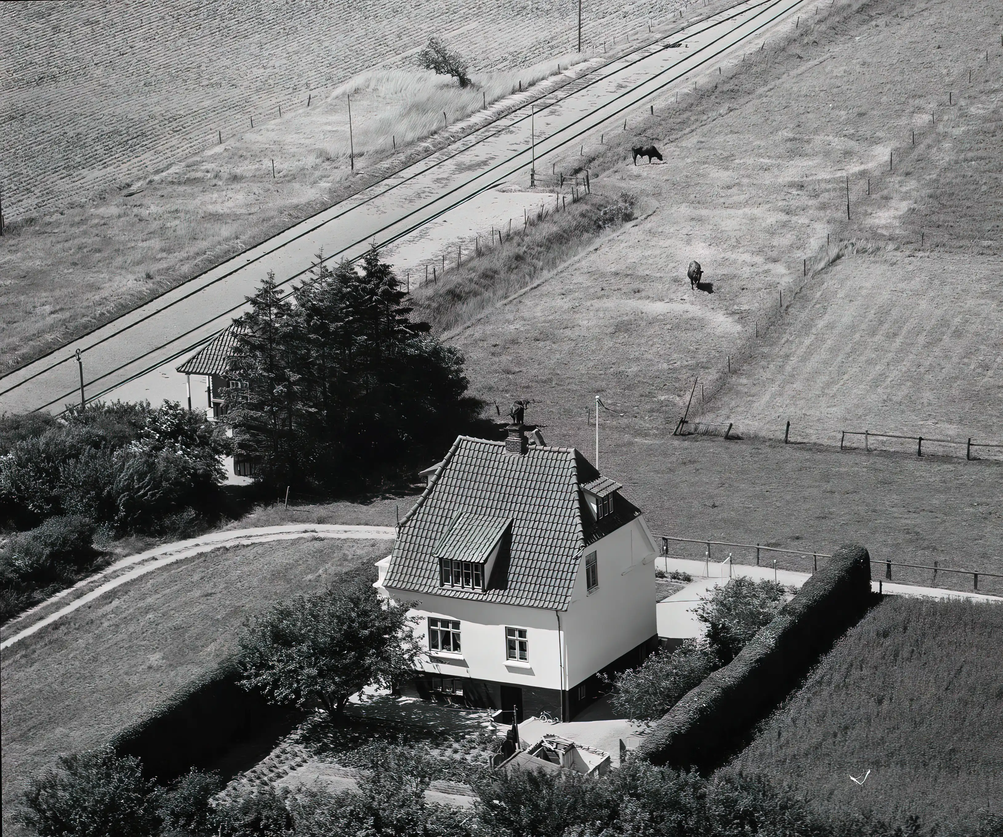 Billede af Yderholm Trinbræt - ventebygningen kan lige skimtes bag og til venstre for det store kvadratiske hus. Billede af Yderholm Trinbræt - ventebygningen kan lige skimtes bag og til venstre for det store kvadratiske hus.