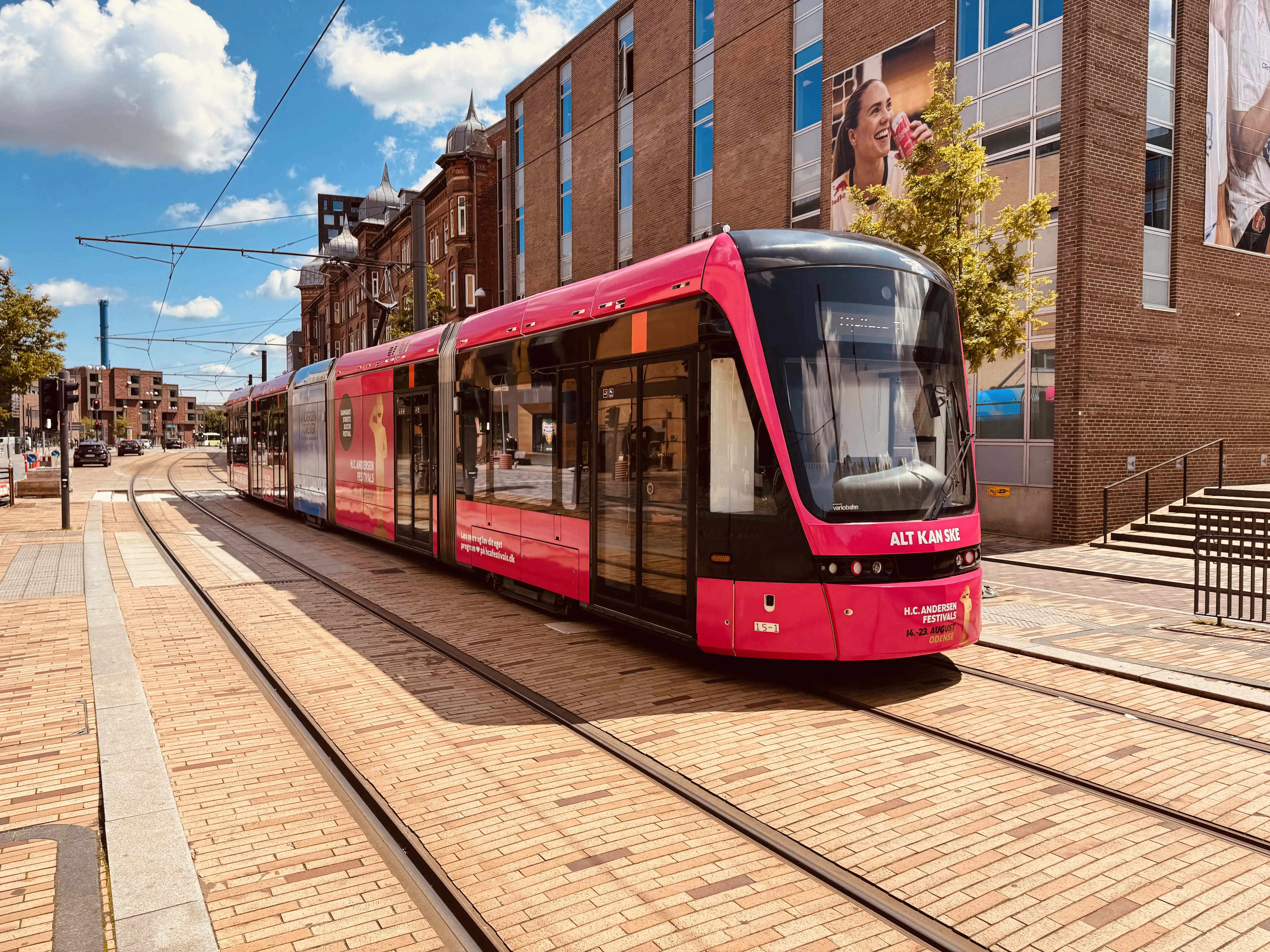 Billede af Odense Letbane togsæt 15 i HCA Festivalsforklædning fotograferet ud for Odense Banegård Letbanestation.