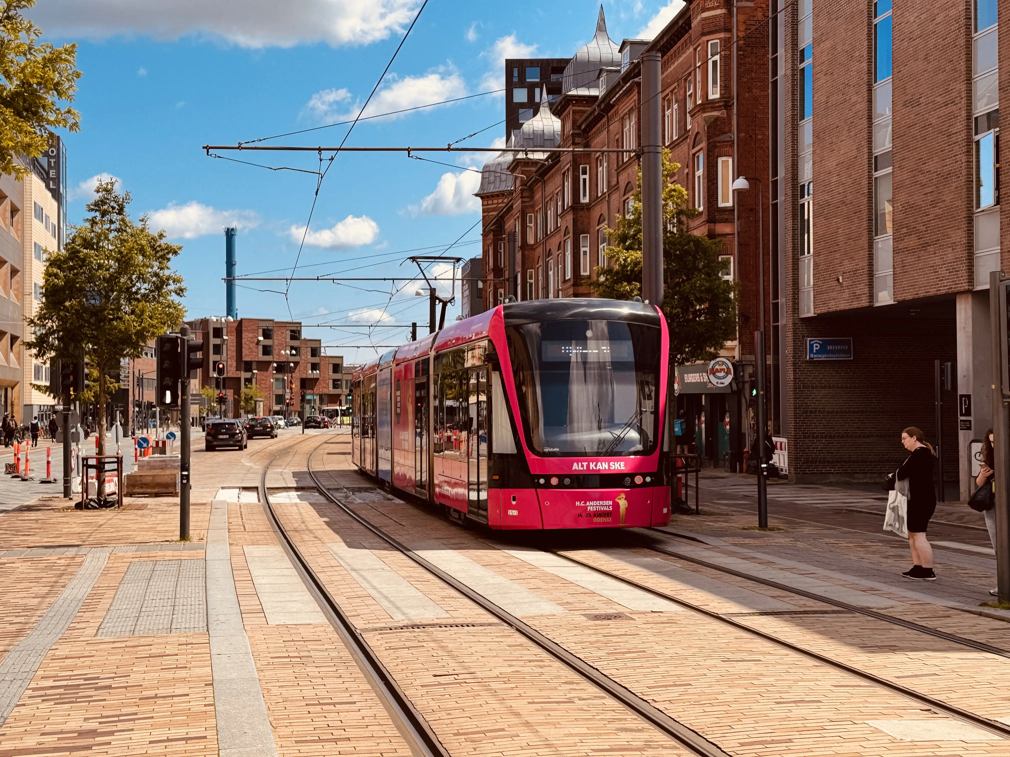Billede af Odense Letbane togsæt 15 i HCA Festivalsforklædning fotograferet ud for Odense Banegård Letbanestation.