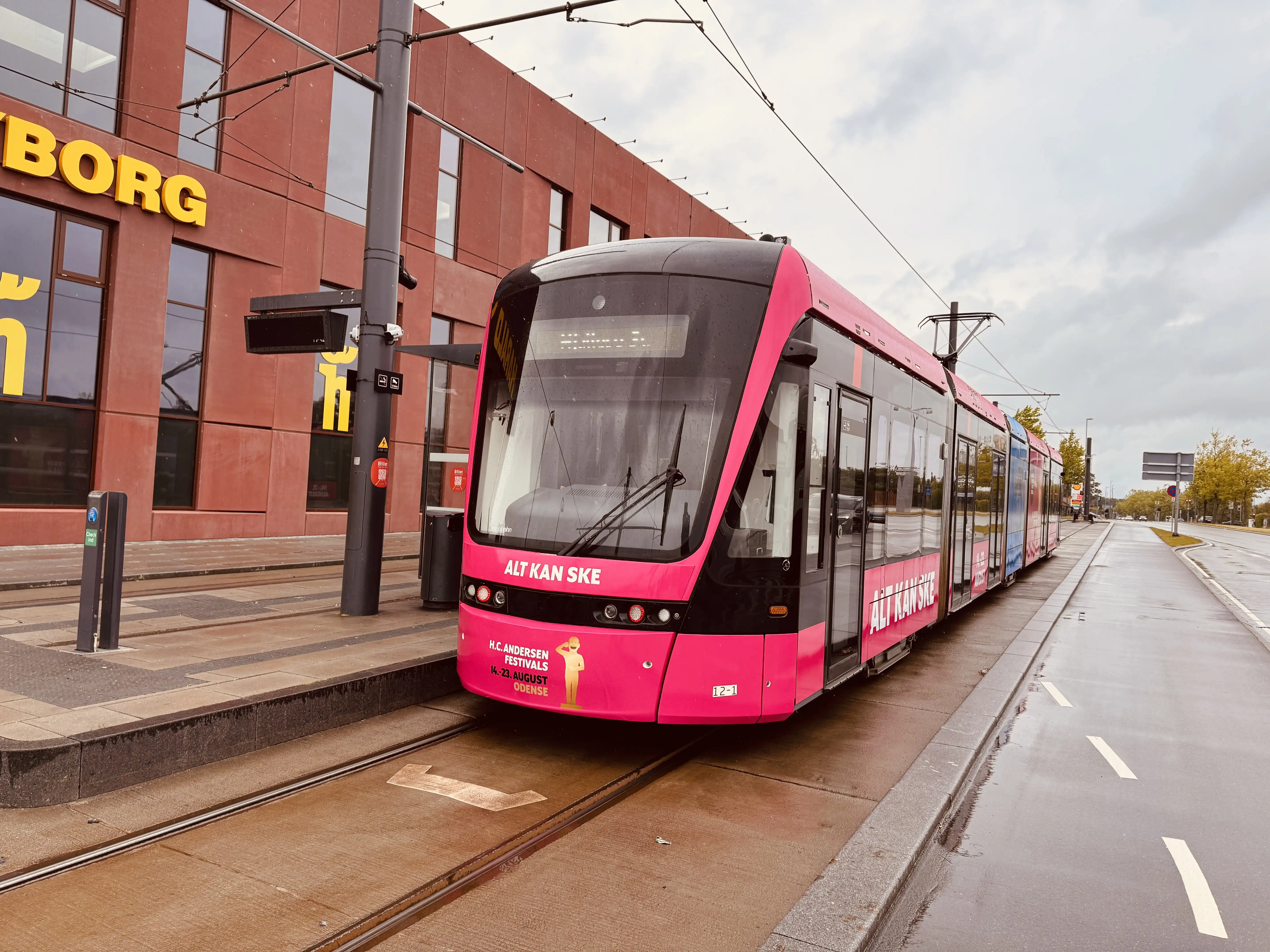 Billede af Odense Letbane togsæt 12 i HCA Festivalsforklædning fotograferet ud for Tarup Center Letbanestation.