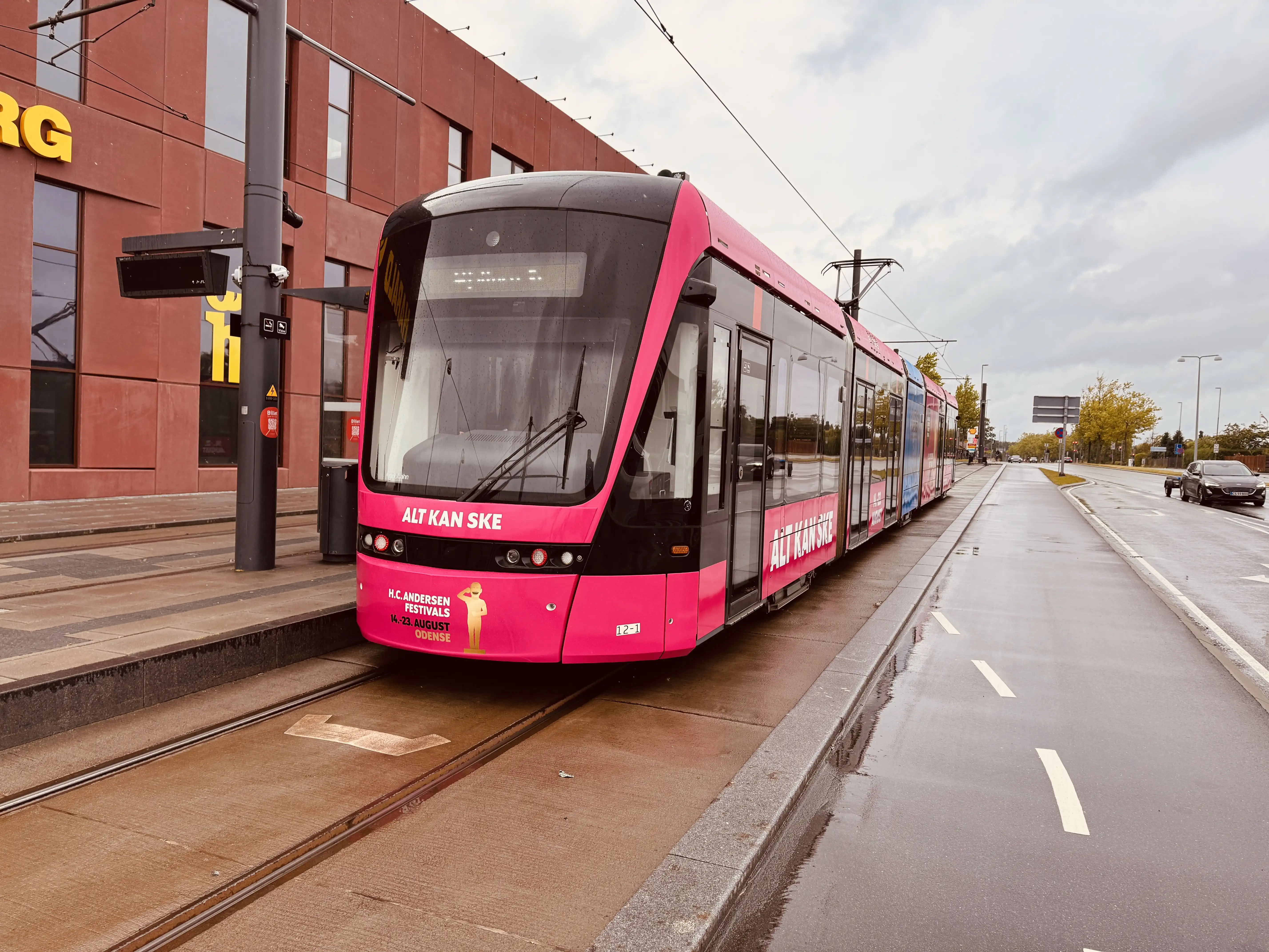 Billede af Odense Letbane togsæt 12 i HCA Festivalsforklædning fotograferet ud for Tarup Center Letbanestation.