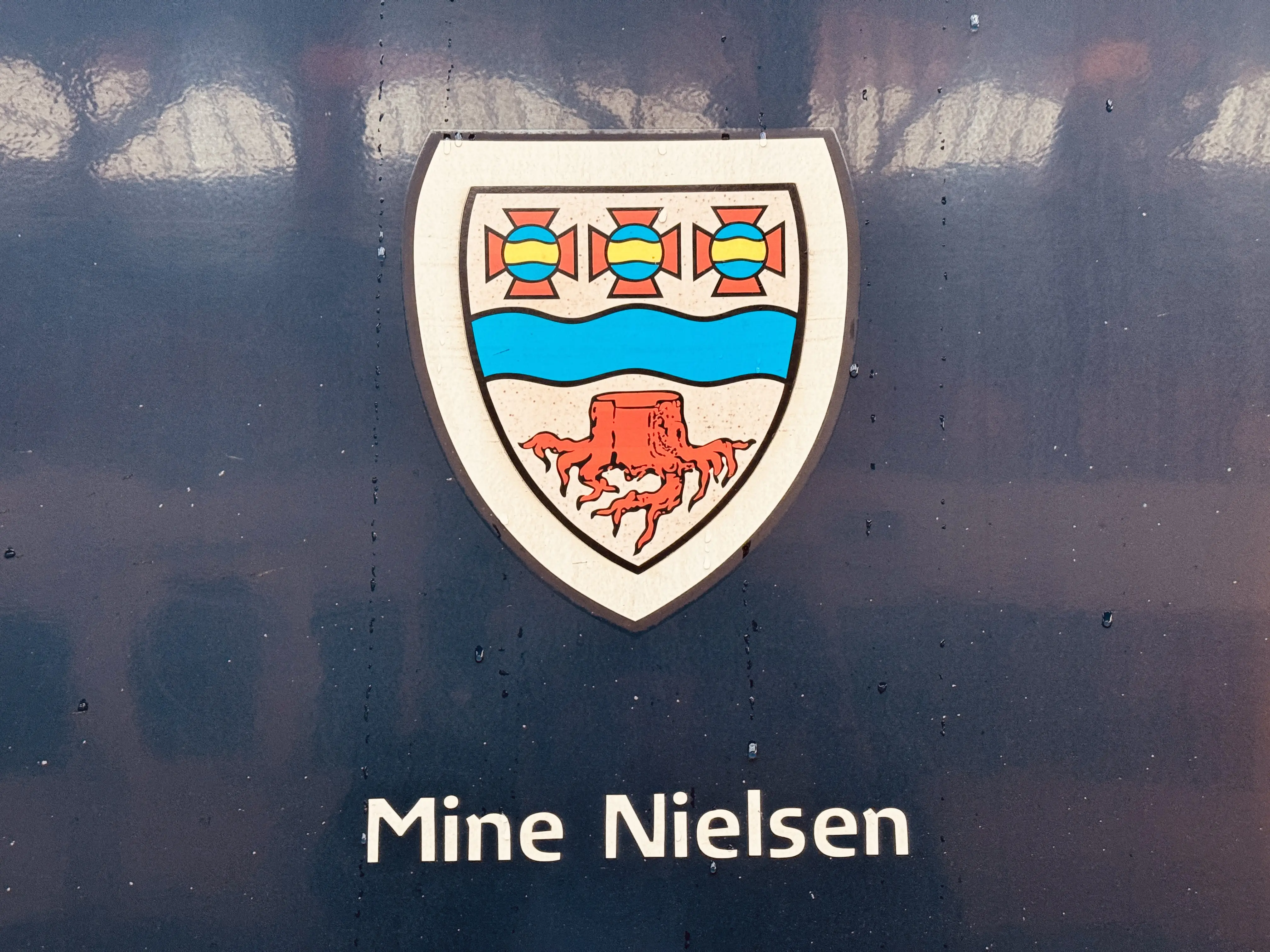 Billede af Langaas byvåben og navngivet "Mine Nielsen" på siden af DSB MF 5002 fotograferet ud for København Hovedbanegård.