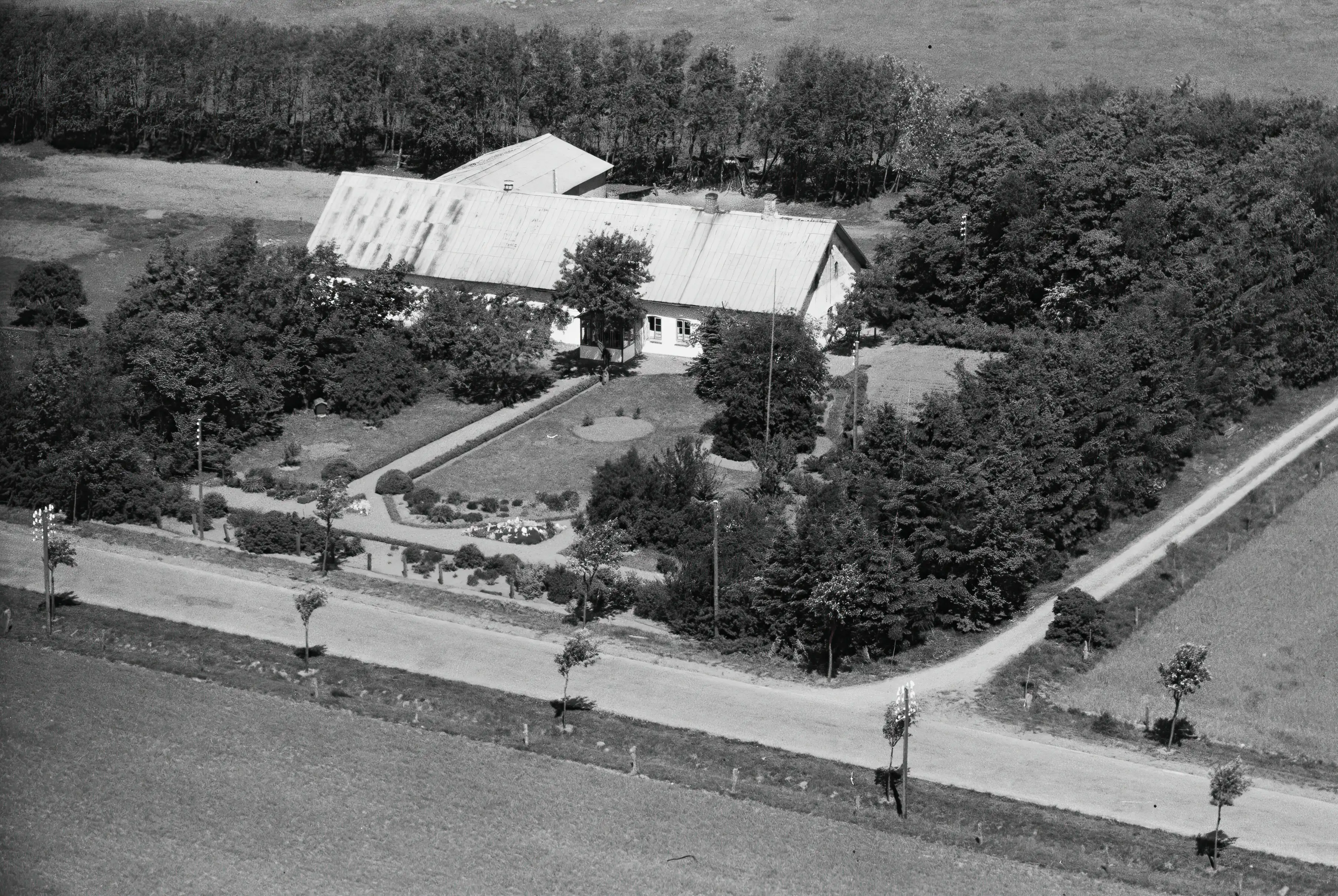 Billede af Lønholm Trinbræt, hvor Trinbrættet lå for enden af havegangen ud mod vejen. Havegangen forbandt Trinbrættet med venteværelset på gården.